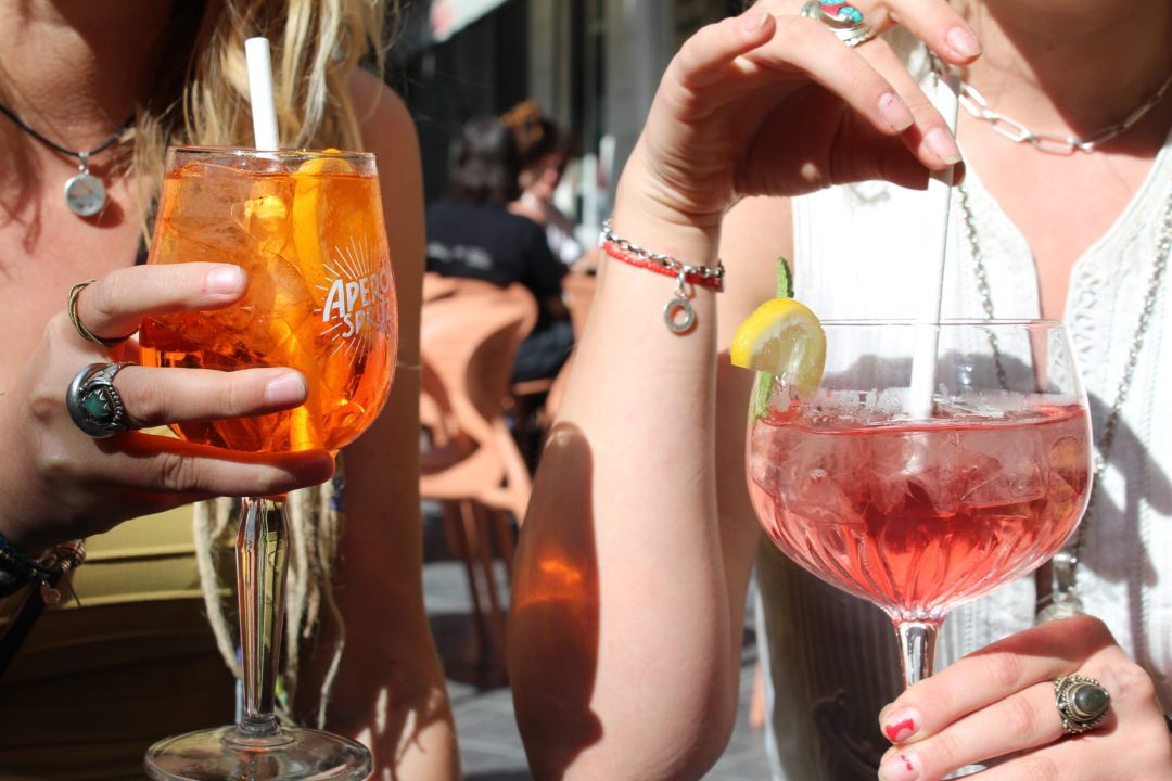 Several shots aligned neatly on a bar. The shots are dark brown in colour. The background is blurred.